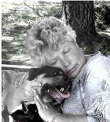 A woman hugging her dog as the dog looks at her lovingly
